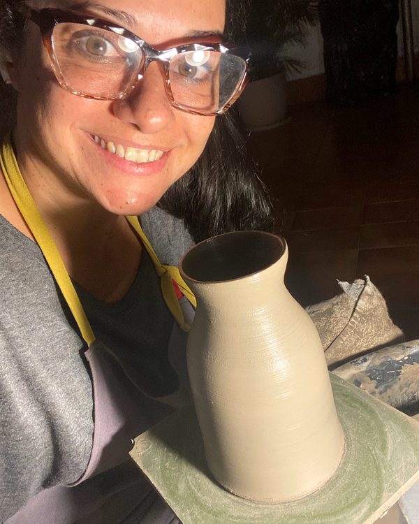 Maria Fernanda no torno, ao lado de um vaso recém-torneado